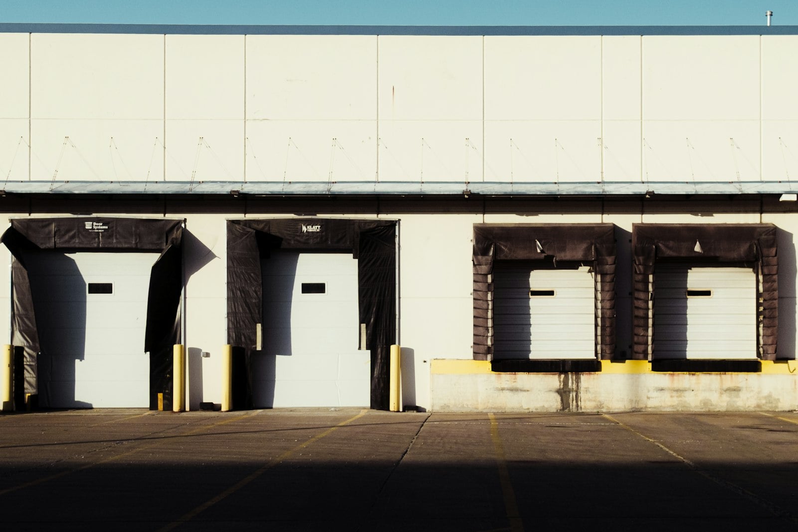 Row of loading dock bays with white roll-up doors