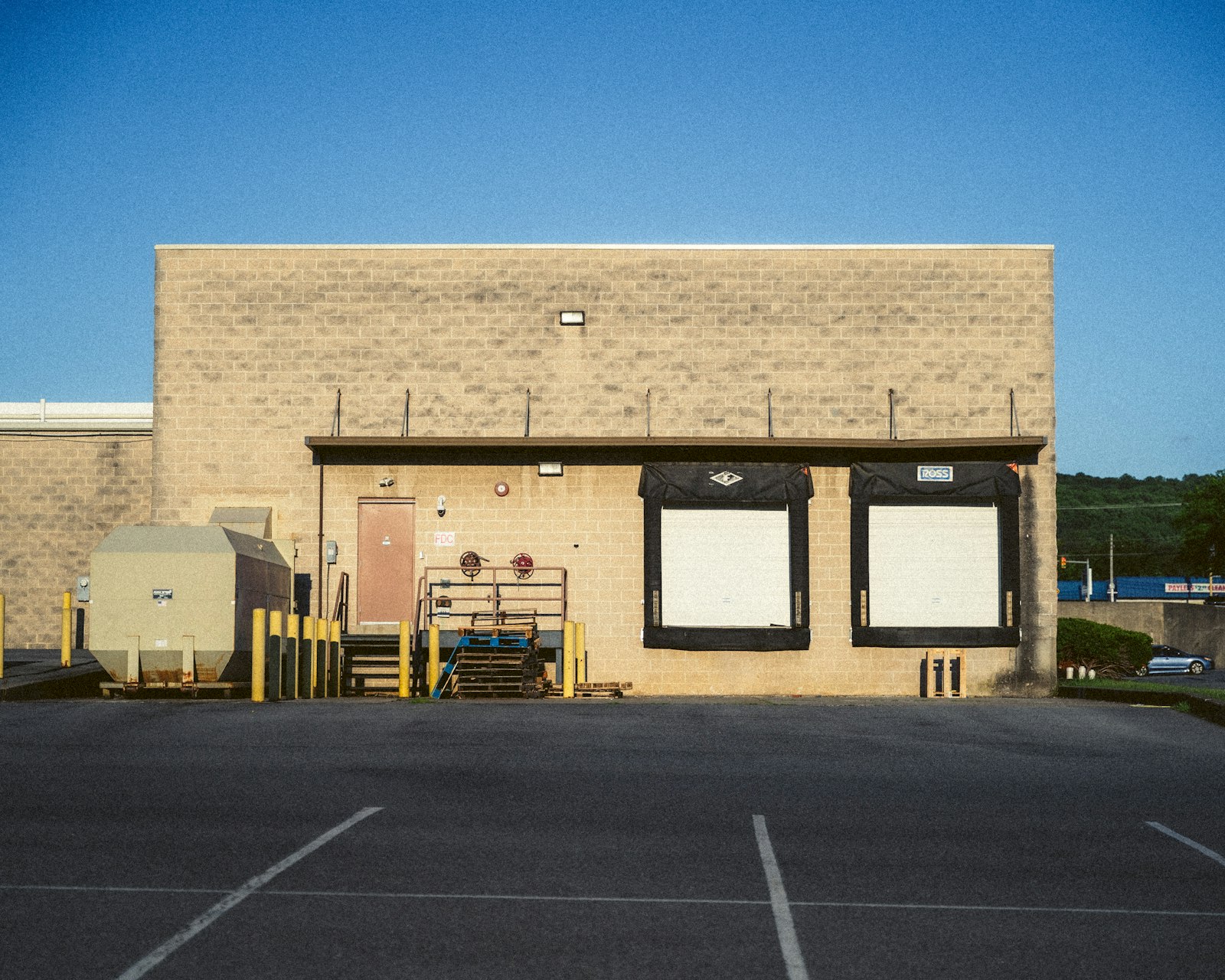 Two white dock doors on a block warehouse wall