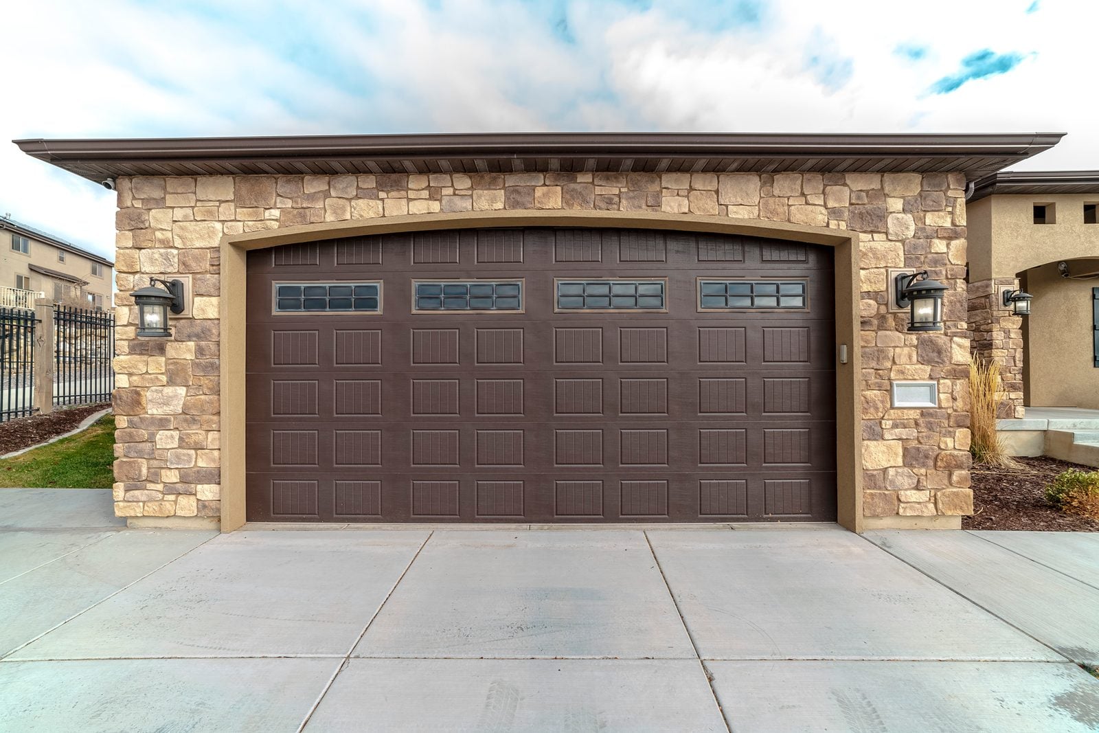 Brown double garage door on a stone-front garage